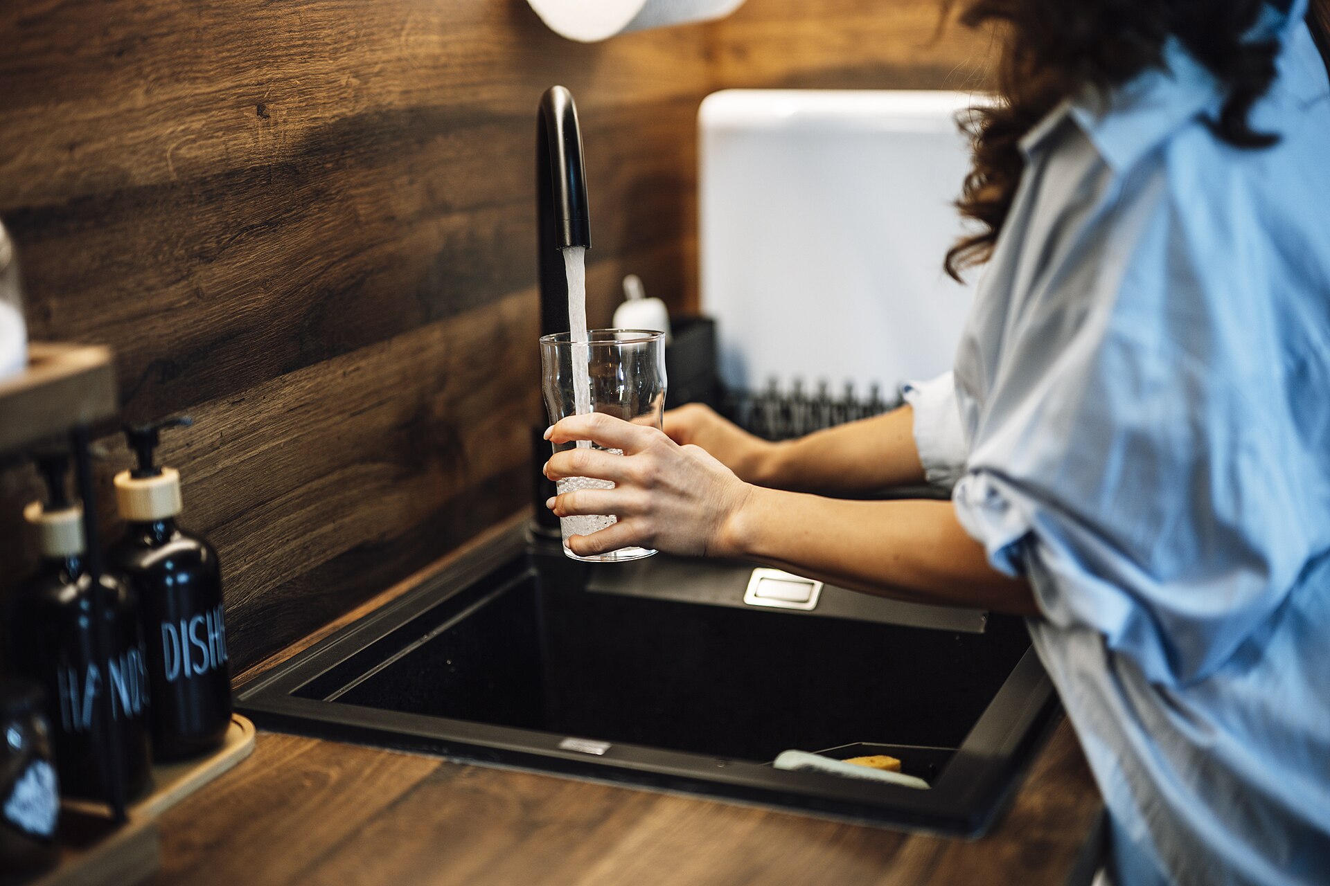 Clean, filtered water pouring into a glass at a kitchen sink in a Raleigh, NC home